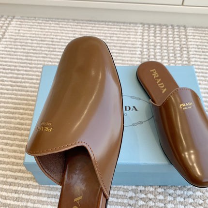 MULES IN BROWN GLOSSY SHEEPSKIN GOLD LETTERING LOGO