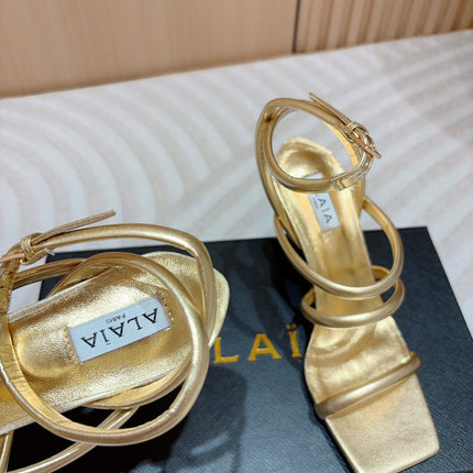 ALAIA THREE-STRAPS HIGH HEEL SANDALS IN GOLDEN PATENT LAMBSKIN
