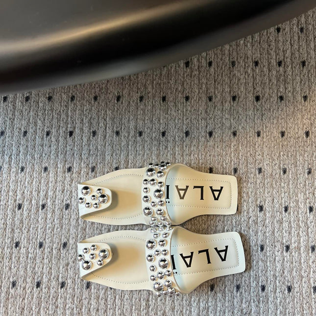 ALAIA FOLDED FLAT MULES WITH SPHERES ON WHITE CALFSKIN