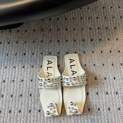 ALAIA FOLDED FLAT MULES WITH SPHERES ON WHITE CALFSKIN
