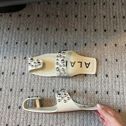 ALAIA FOLDED FLAT MULES WITH SPHERES ON WHITE CALFSKIN