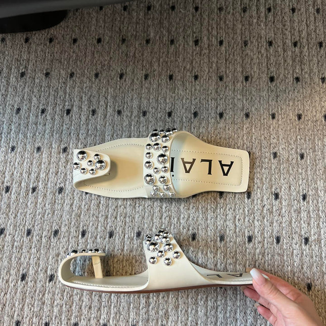ALAIA FOLDED FLAT MULES WITH SPHERES ON WHITE CALFSKIN