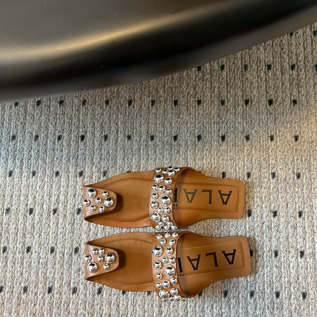 ALAIA FOLDED FLAT MULES WITH SPHERES ON COPPER BROWN CALFSKIN