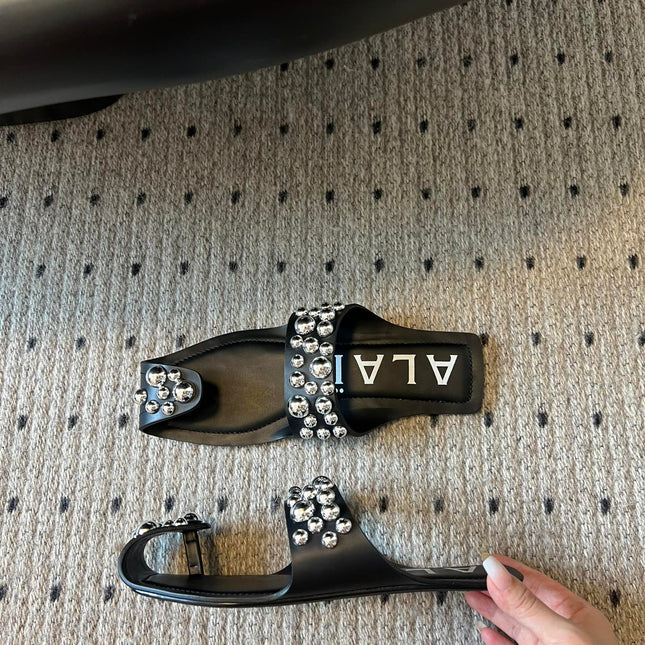 ALAIA FOLDED FLAT MULES WITH SPHERES ON BLACK CALFSKIN