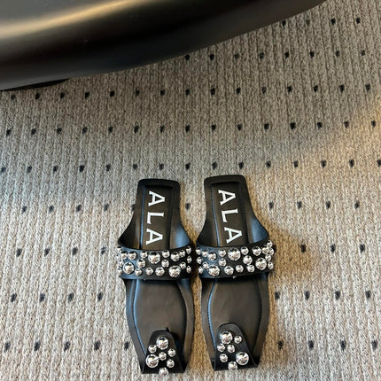 ALAIA FOLDED FLAT MULES WITH SPHERES ON BLACK CALFSKIN