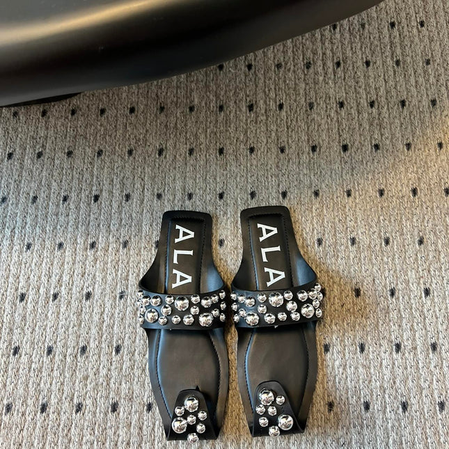 ALAIA FOLDED FLAT MULES WITH SPHERES ON BLACK CALFSKIN