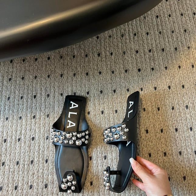 ALAIA FOLDED FLAT MULES WITH SPHERES ON BLACK CALFSKIN