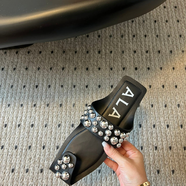 ALAIA FOLDED FLAT MULES WITH SPHERES ON BLACK CALFSKIN