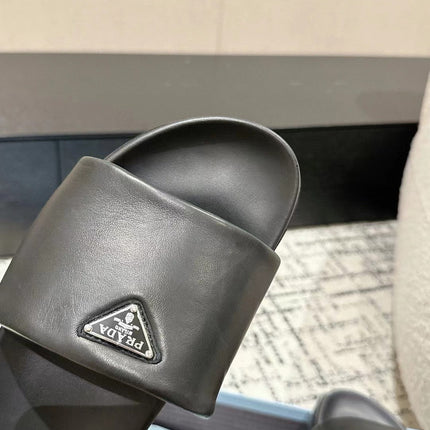 PRADA 25S PADDED SLIDES IN BLACK CALFSKIN WITH LOGO