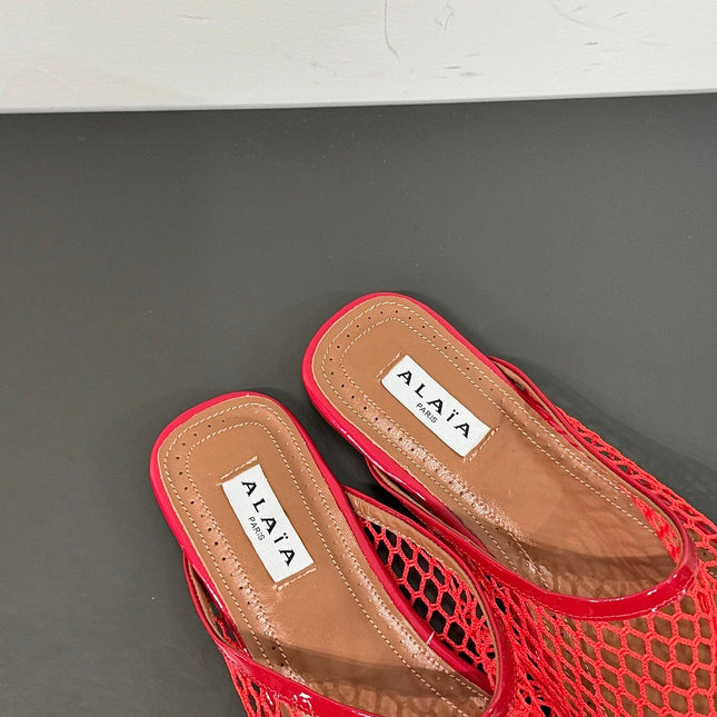 ALAIA FLAT MULES IN CHERRY RED MESH FISHNET