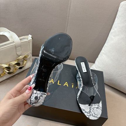 ALAIA HEELED THONG 25S 55 MM IN WHITE AND BLACK LAMBSKIN SNAKE-EMBOSSED WITH CLEAR STRAP