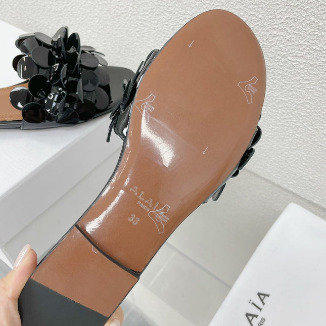ALAIA FLAT MULE IN BLACK GLOSSY LAMBSKIN