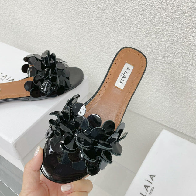 ALAIA FLAT MULE IN BLACK GLOSSY LAMBSKIN