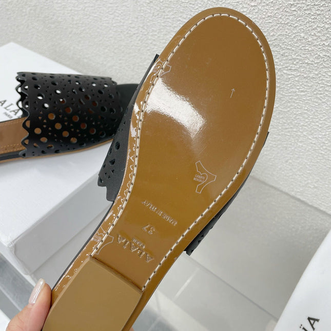 ALAIA VIENNE FLAT MULES IN BLACK LAMBSKIN
