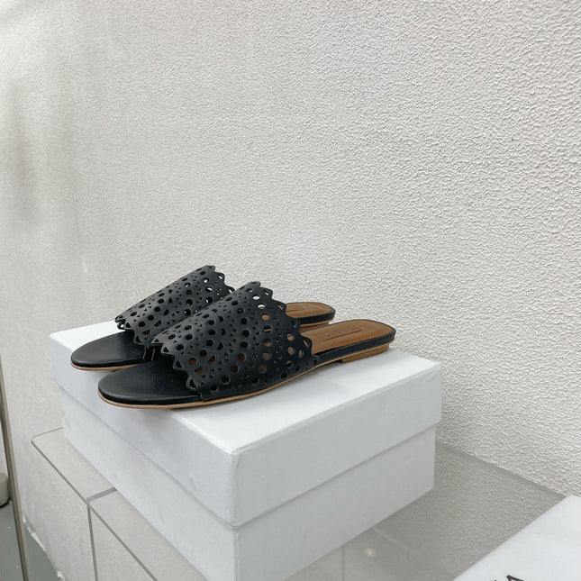 ALAIA VIENNE FLAT MULES IN BLACK LAMBSKIN