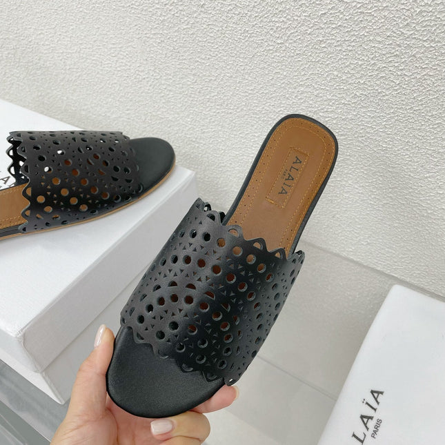 ALAIA VIENNE FLAT MULES IN BLACK LAMBSKIN