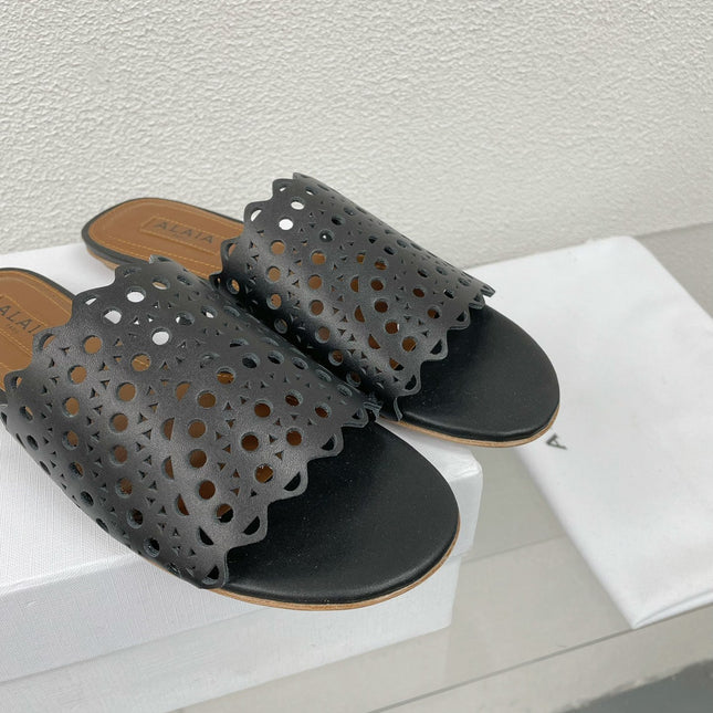 ALAIA VIENNE FLAT MULES IN BLACK LAMBSKIN