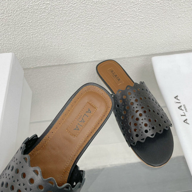 ALAIA VIENNE FLAT MULES IN BLACK LAMBSKIN