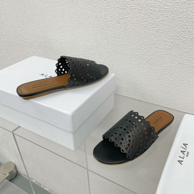 ALAIA VIENNE FLAT MULES IN BLACK LAMBSKIN
